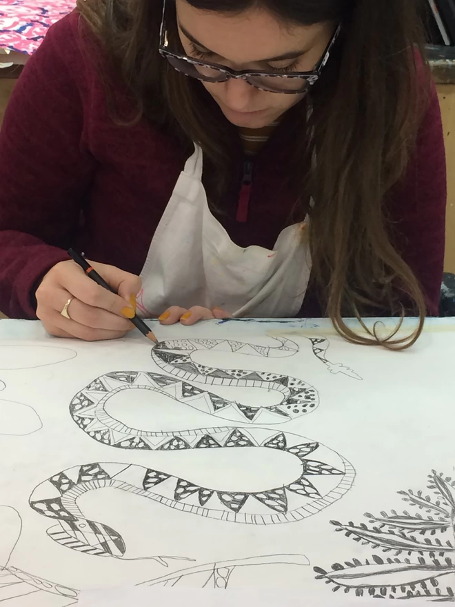 Artists drawing original artwork for enchanted, amber & tonka bean candle in a reusable glass