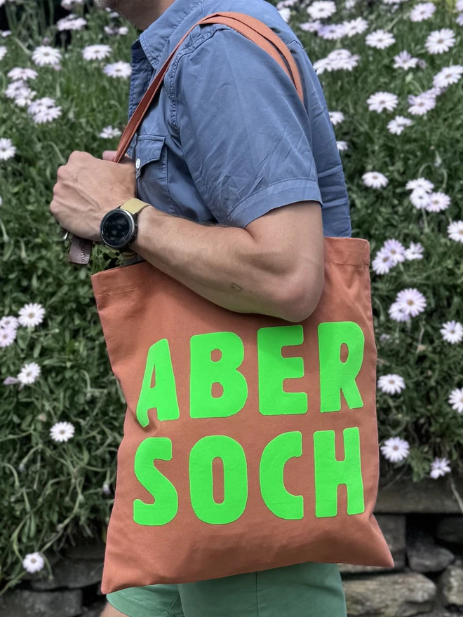 bright green destination bag abersoch against a flowery bacdrop