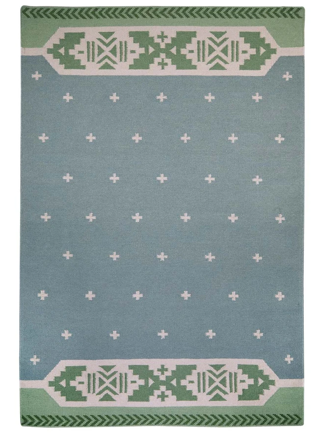 Manali Flatweave Rug, a colourful rug sitting on a plain surface. 