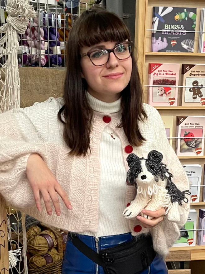 Jess the Border Collie Knitting Kit. A woman holding a small, knitted border collie.