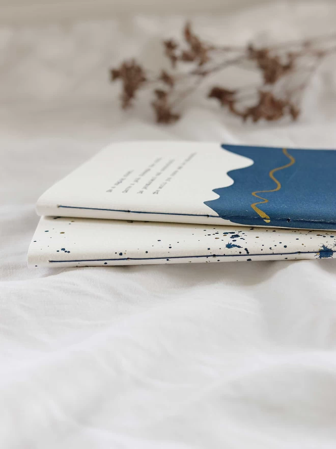 Hand stitching on blue and gold personalised journals
