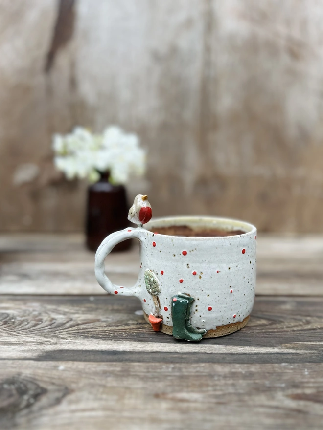 Robin perching on a cream mug