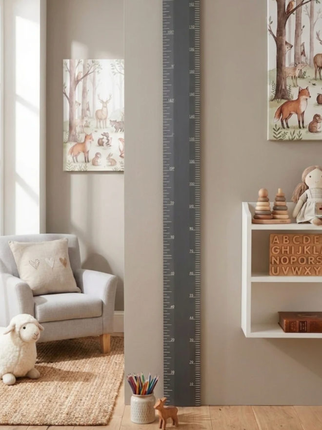 Wooden Height Chart. A large ruler height chart in Downpipe leaning against a child’s wall.
