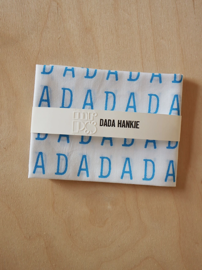 A Mr.PS DADA hankie folded with an embossed paper wrap