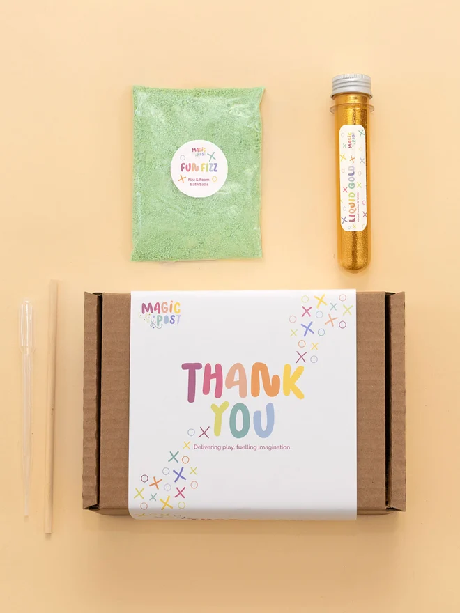 sensory party potion box. tube of gold glitter and green bath salts photographed with packaging box.