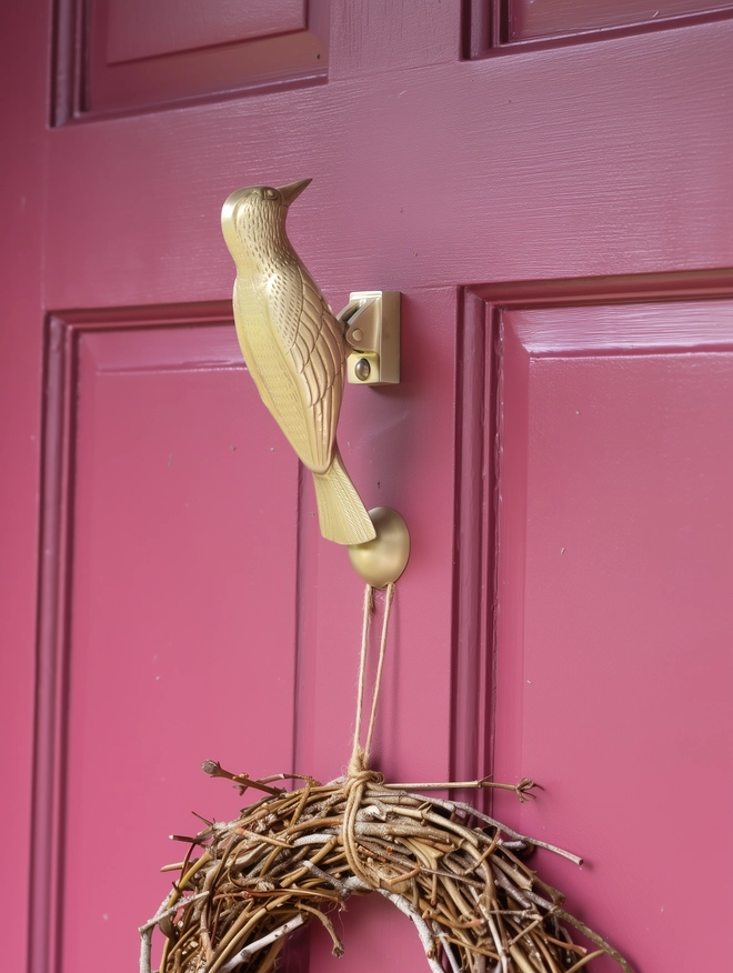 Woodpecker door knocker on red door