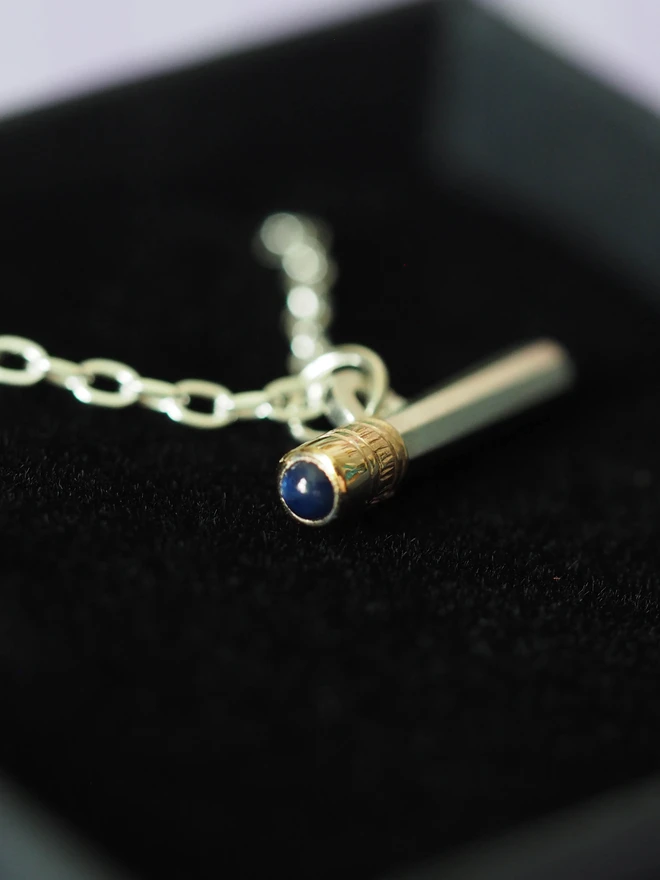 Sapphire dinky pencil charm on a necklace in a gift box