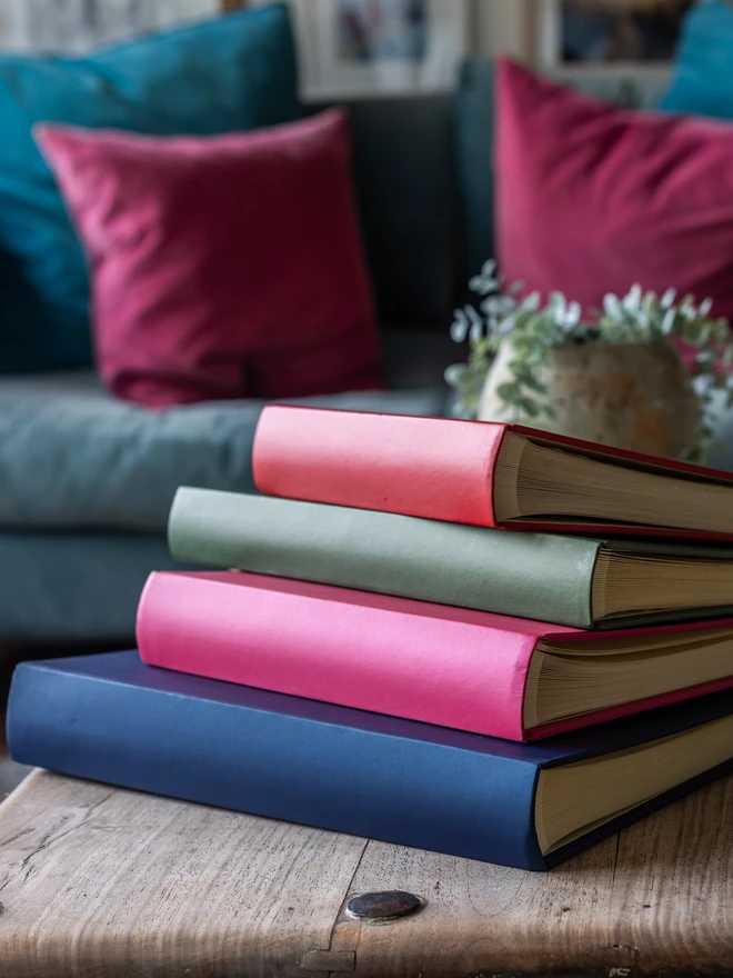 Pile of Plain Cover 'Jewel' Hardback Photo Albums of different sizes, stacked on a wooden table.