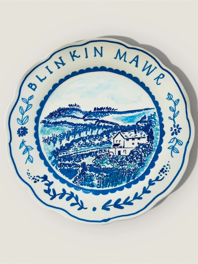 Hand-painted cottage in blue and white on a plate. Folksy and gentle whimsy in a Circle of Willis style.