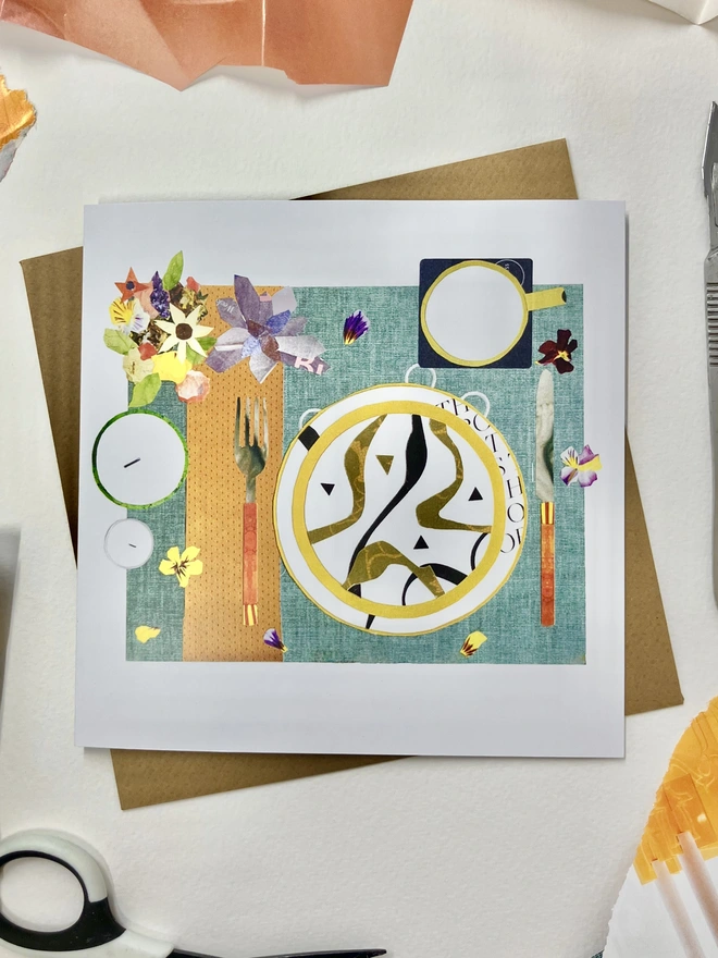 dinner party table setting collage on a greetings card with a brown envelope on a background of  collage materials