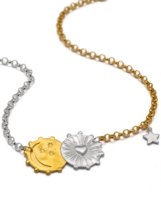 Embrace the magic of the cosmos with the Lunar Glow Double Coin Necklace. Crafted in sterling silver with 18ct gold plate, this tactile two-tone design features a heart sunburst and moon-and-stars motif, engraved on the reverse with “My sun, my moon and all my stars.” Finished with a delicate star charm on a mixed-metal belcher chain.