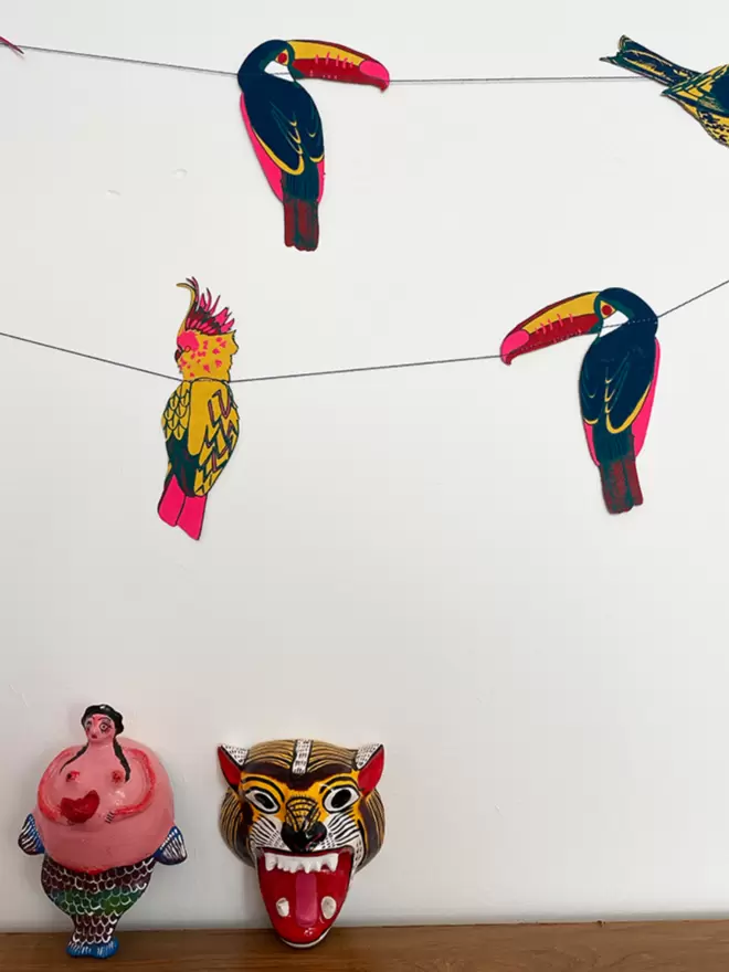 Close up of blue toucans and yellow cockatoos on a white wall