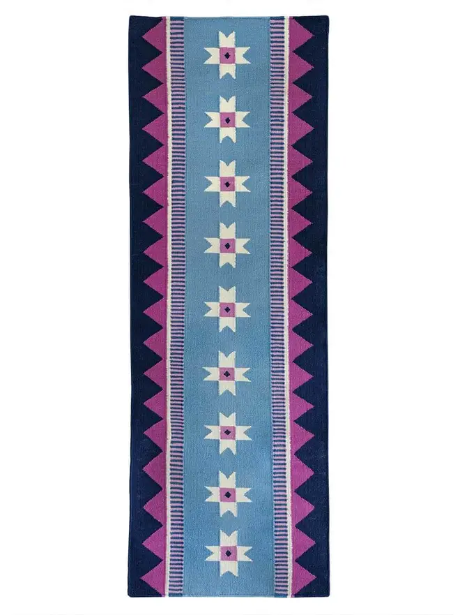 Victoria Flatweave Runner Rug, a colourful rug sitting on a white surface. 