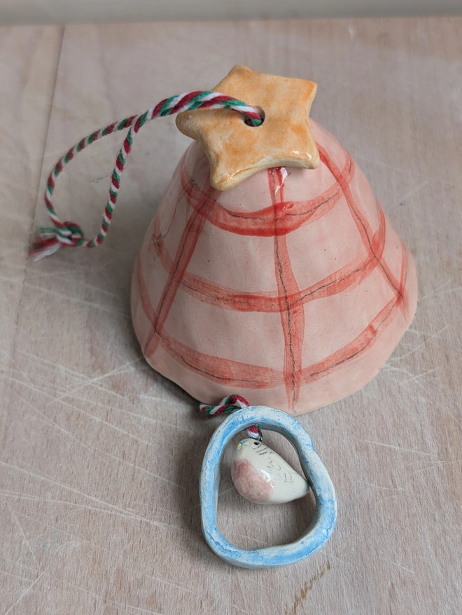 pink and red check bell with an orange star pink budgie bird bell