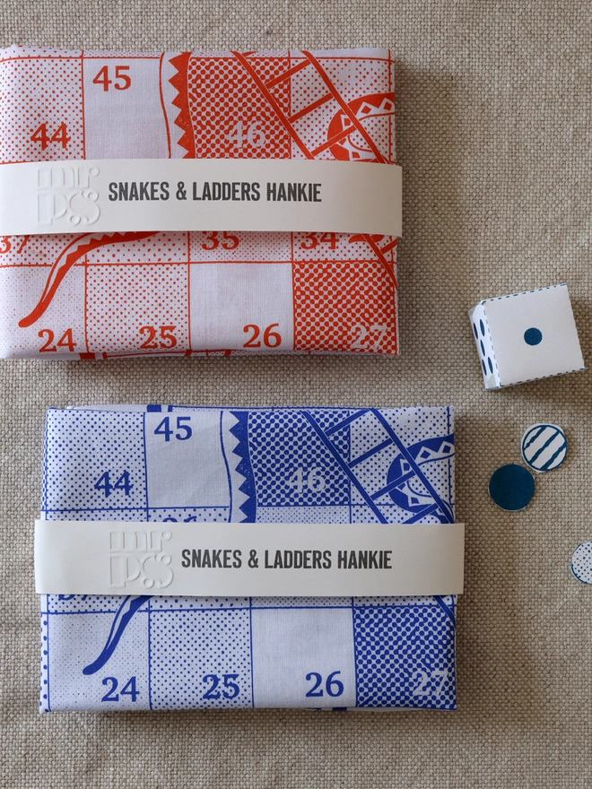 2 folded Mr.PS Snakes & Ladders hankies, 1 in orange and 1 in blue