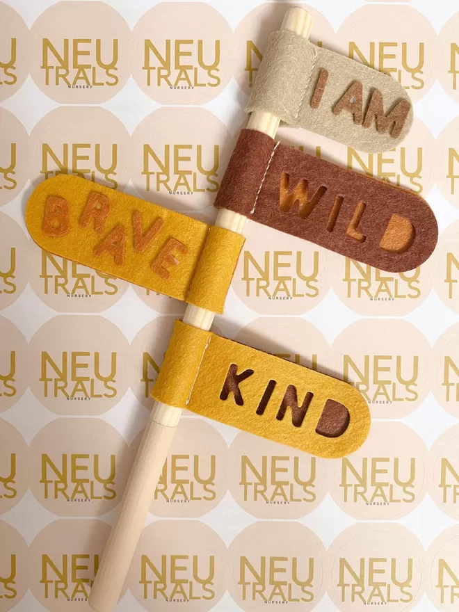Swizzler stick with yellow and brown tabs that say I am wild, brave, kind