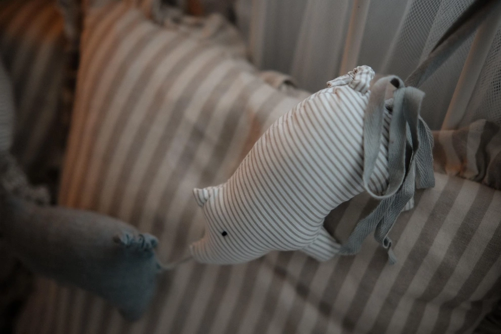 Pig Garland Decoration, a grey and white pig garland decoration in a child's bedroom. It is accompanied by other bedroom accessories. 