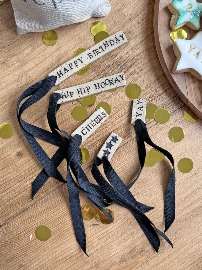 a selection of celebration themed ceramic tags with black ribbon