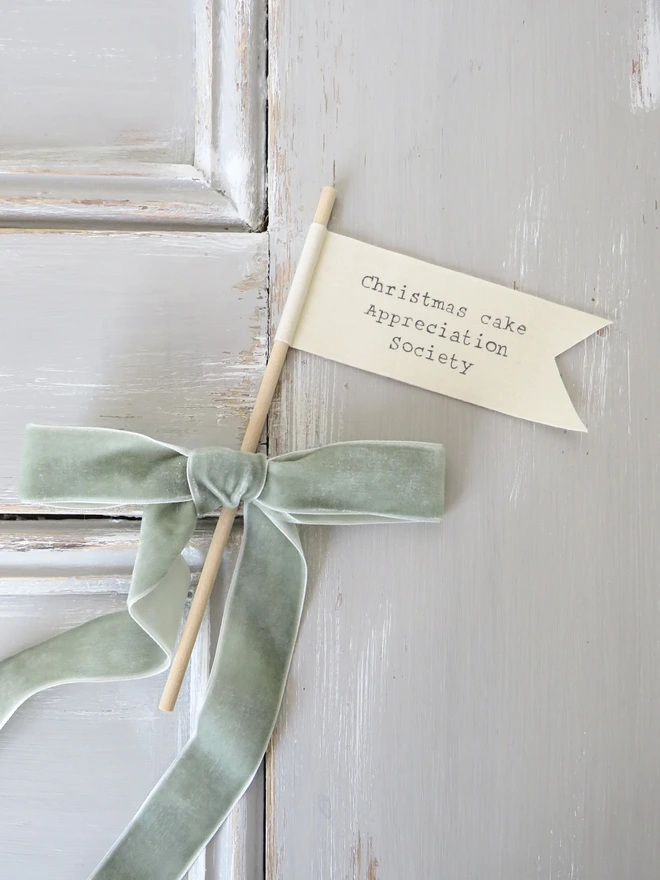 Organic cotton flag hand painted with festive message wrapped around a wooden dowel