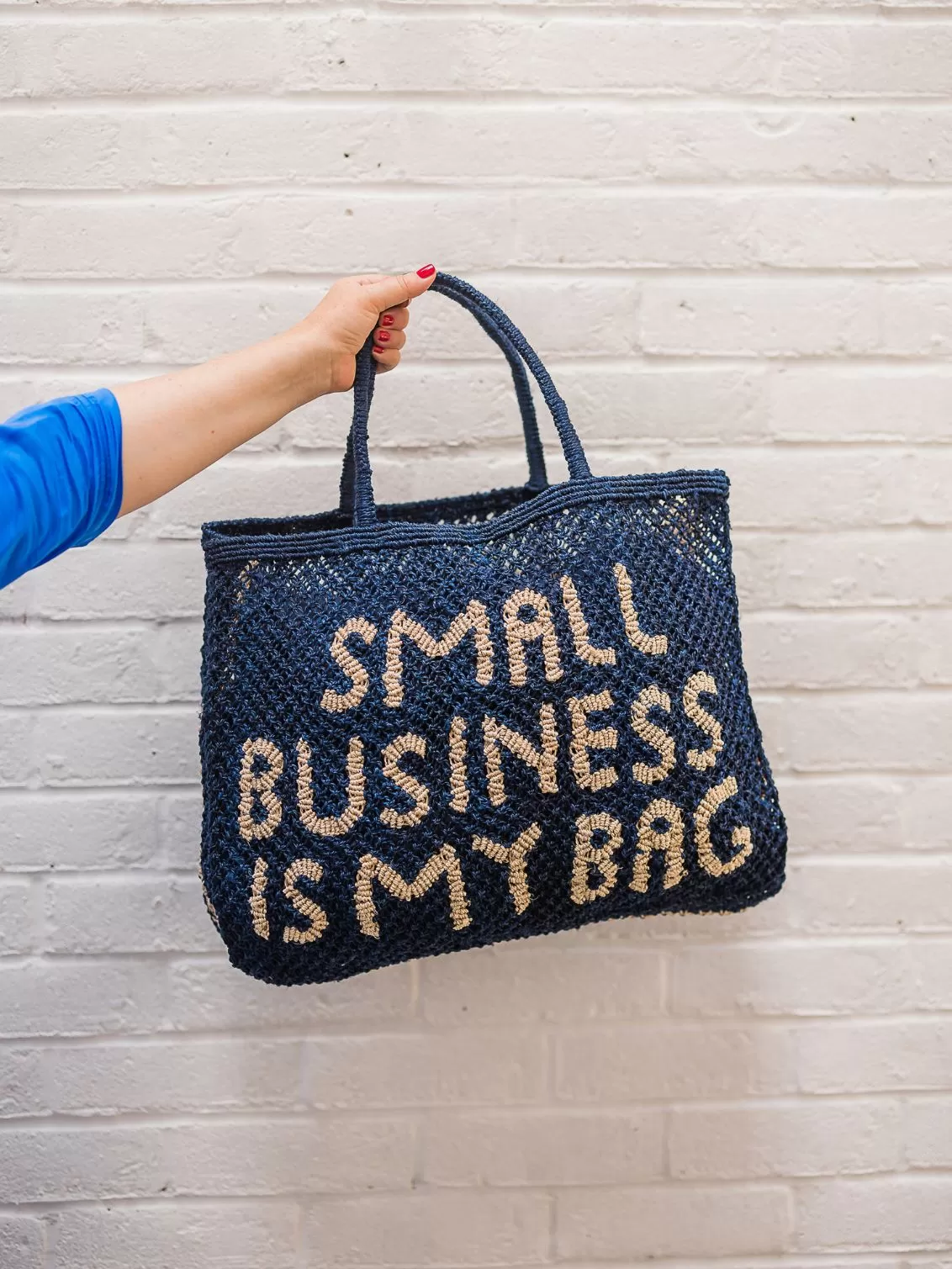 The Jacksons Small Business Is My Bag seen held against a white brick wall.
