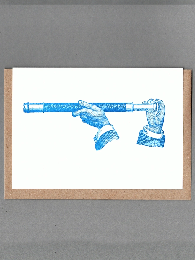 White card with blue illustration of two hands holding a naval telescope with a brown envelope behind