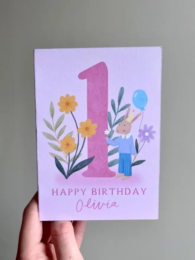 personalised floral 1st birthday card. pink 1st birthday card with illustrated rabbit and flowers.