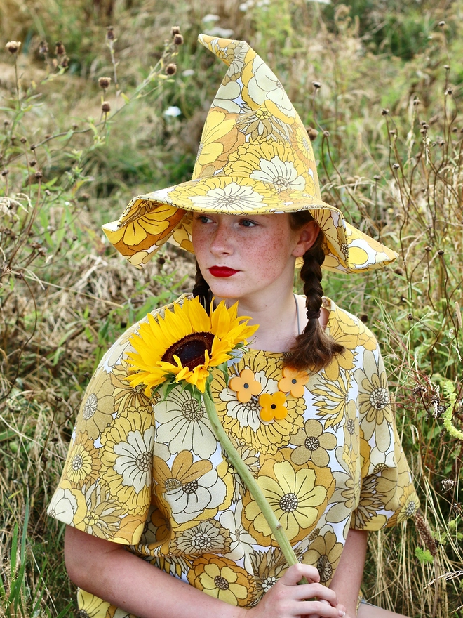 Yellow witch hat on woman