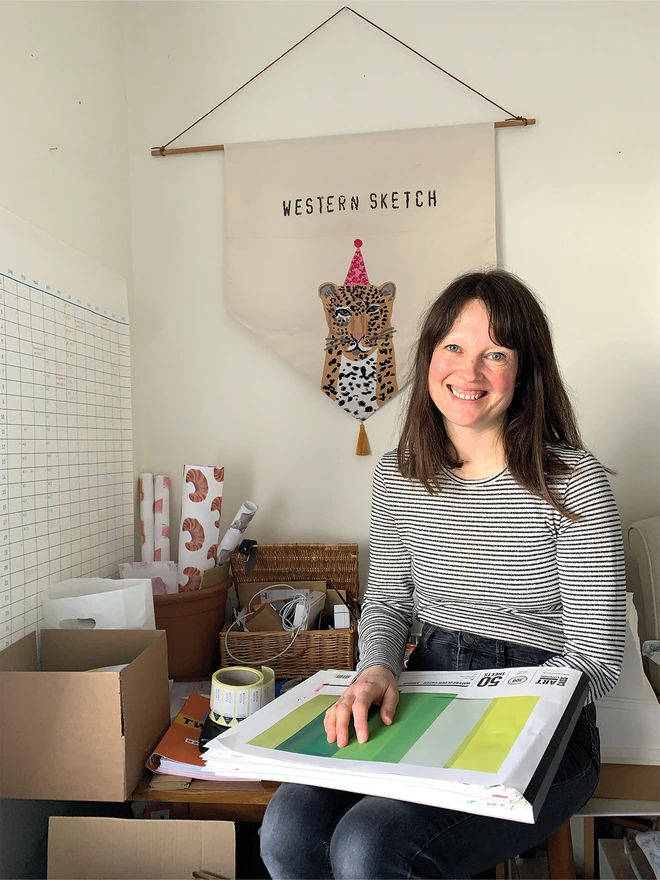 Melissa sitting at her desk with her Sketchbook 