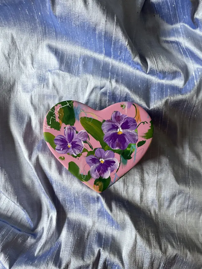 hand painted floral ceramic heart shaped keepsake box background in a pale pink with purple pansy flowers