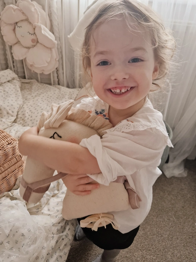 Horse Baby Rattle Toy, a child with a horse baby rattle toy in a bedroom surrounded by other bedroom accessories. 