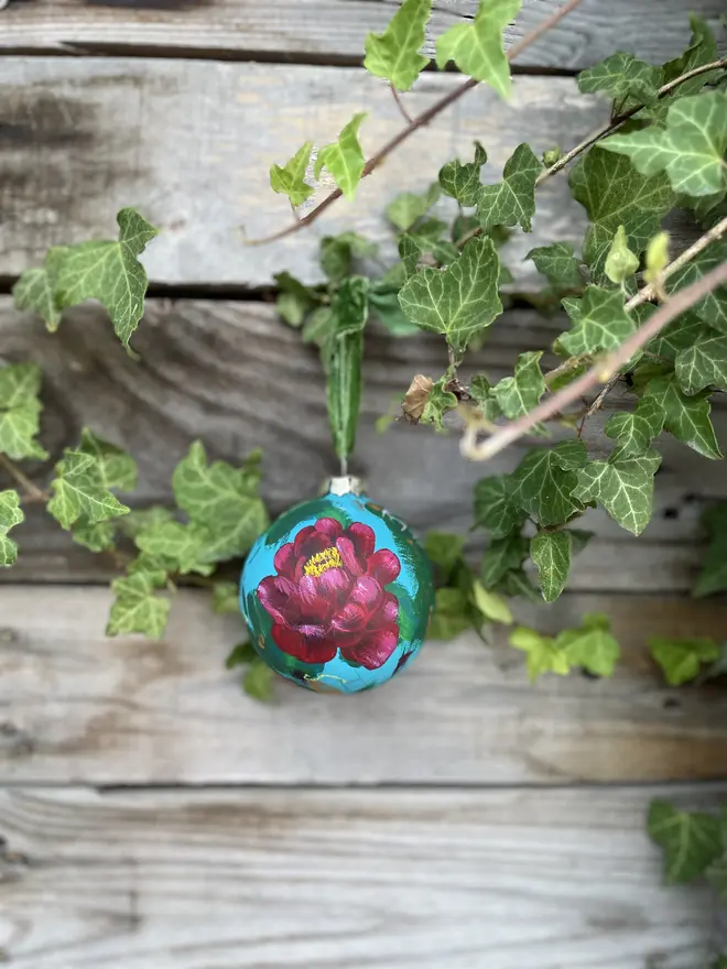 hand painted ceramic floral bauble background painted in a turquoise adorned in rich deep red peony flowers