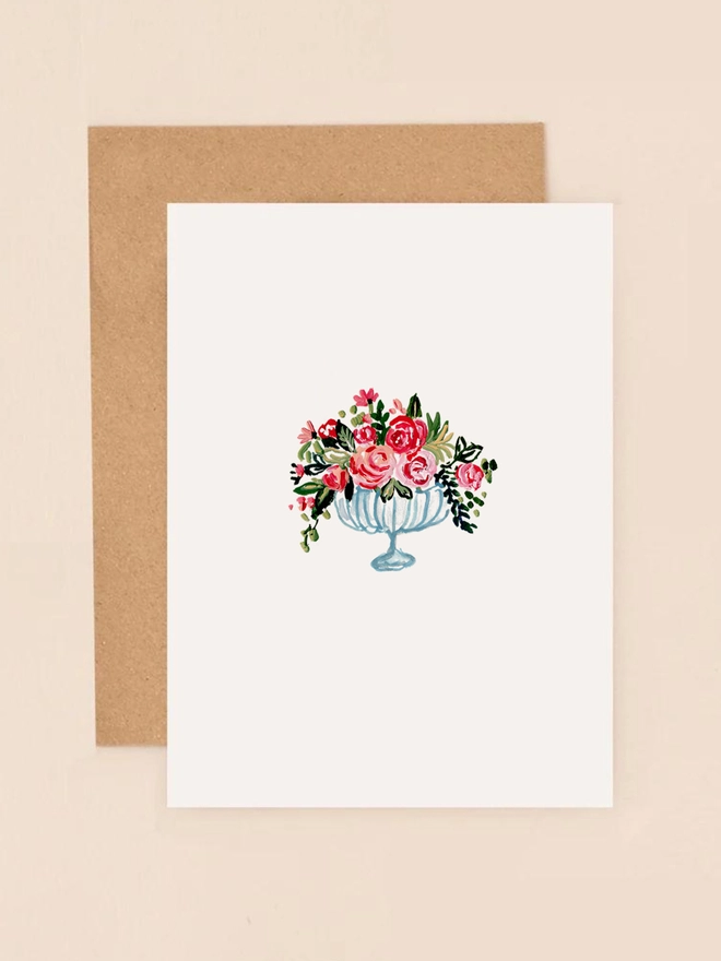 A delicate illustration of a vintage-style glass vase filled with a lush bouquet of soft pink, red, and cream roses. The roses are depicted with intricate detailing, showcasing their gentle petals and natural beauty. The vase sits gracefully against a neutral background, exuding an elegant and timeless charm. This mini card is perfect for expressing appreciation, sending birthday wishes, or conveying heart