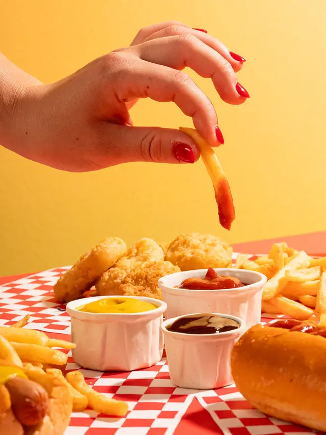 Large Ceramic Sauce Pots (Set Of 3), positioned in a group with food being dipped into them. 