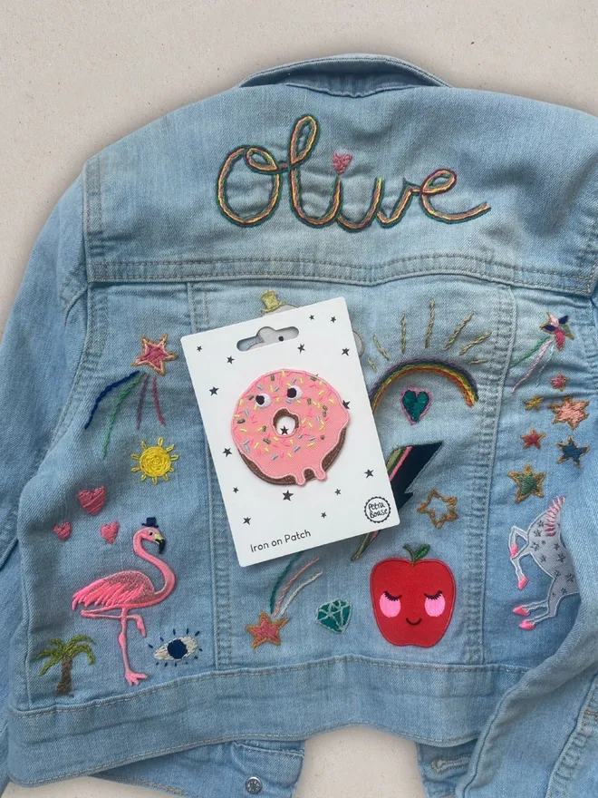 Doughnut embroidered iron on fabric patch on a kids embrodiered denim jacket.