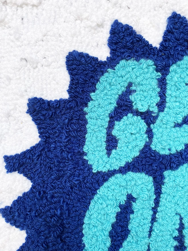 cyan tufted wool lettering on a blue star background