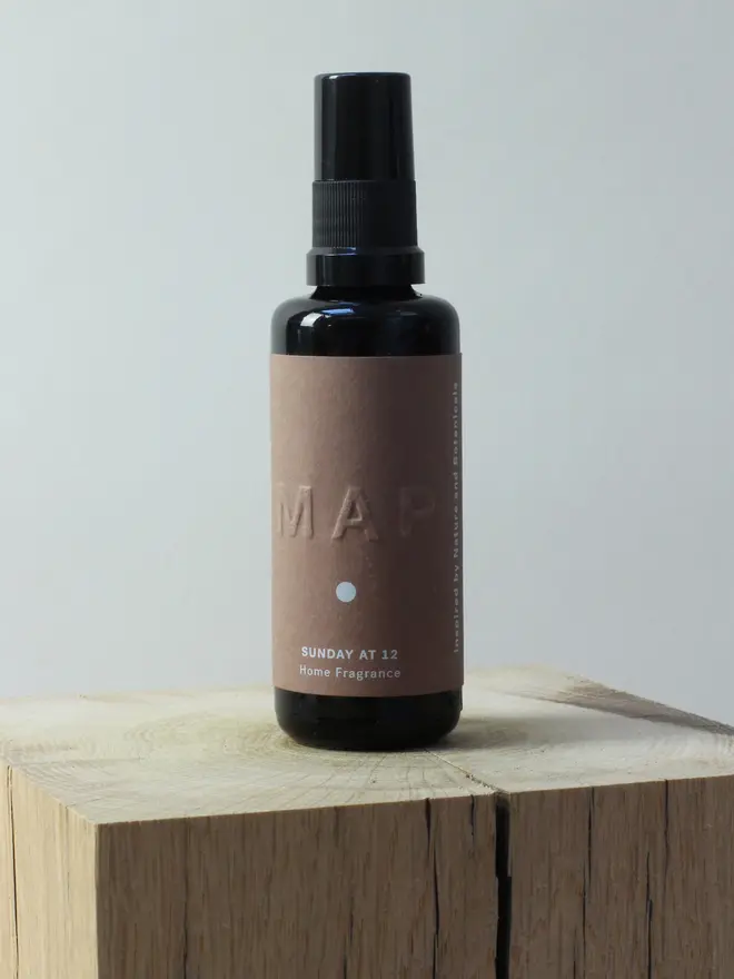sunday at 12 sandalwood and rose home fragrance spray. bottle photographed on wooden surface.