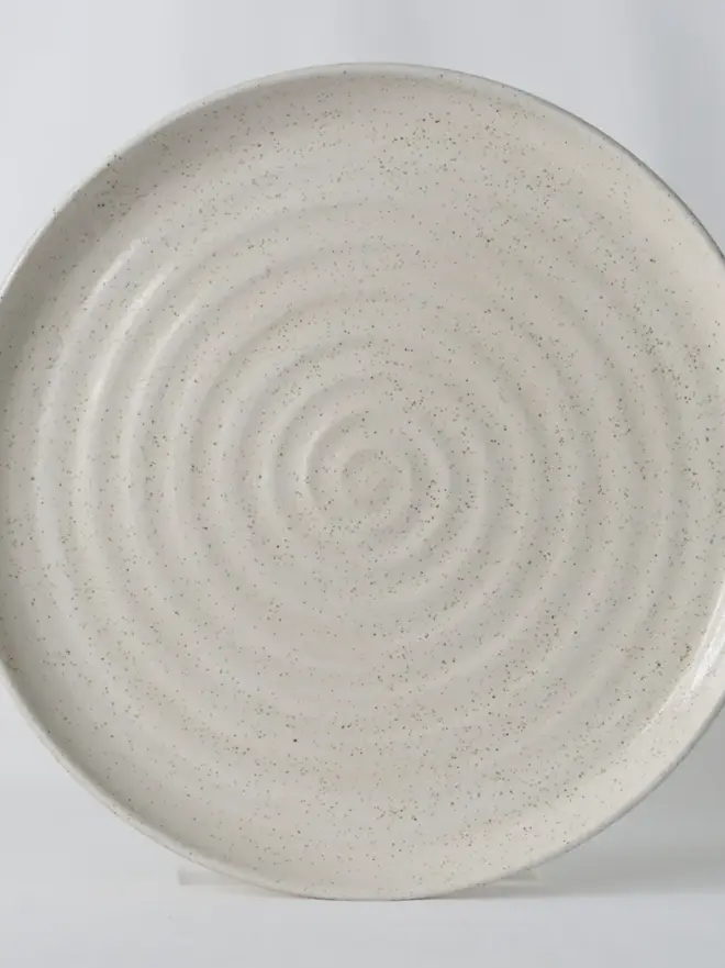white speckled ceramic plate with textured swirl design