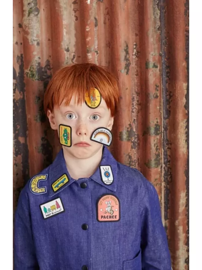 The My First Wheels Patch is shown on a blue shirt along with other Pachee patches placed on a kid's face.