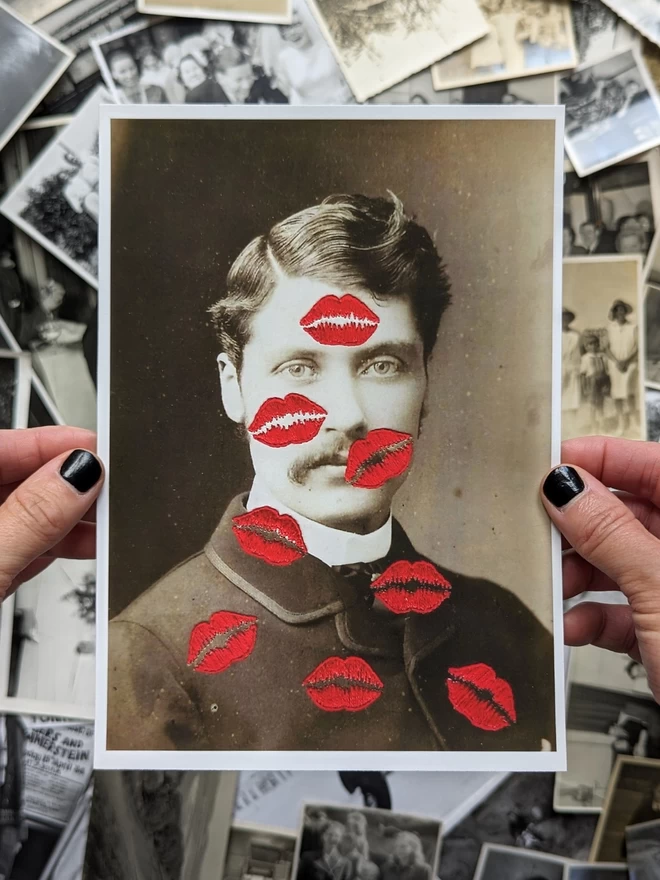 B&W photo print of man covered in embroidered red kisses held against vintage photos