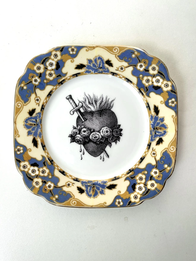 a vintage plate with an ornate gold border and in the centre is an old illustration of a beautiful sacred heart