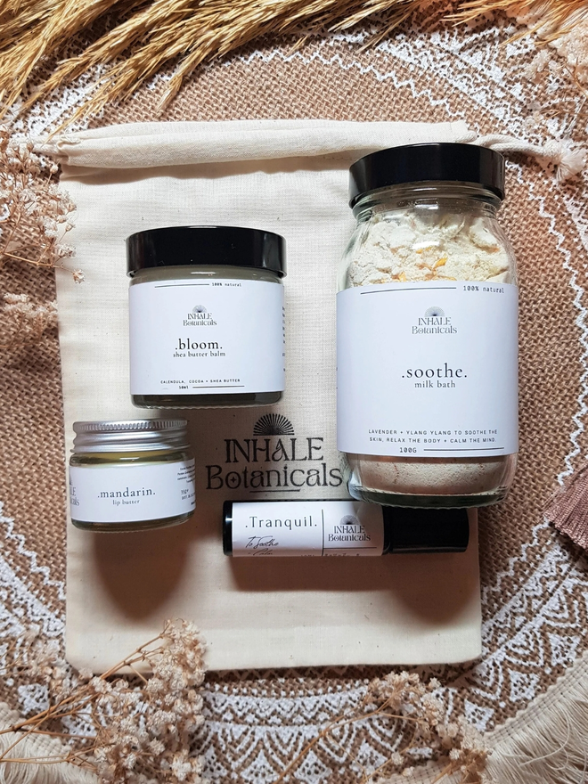 Bath and body gift set. Glass jars with bath salts and lip balm on top of a gift bag