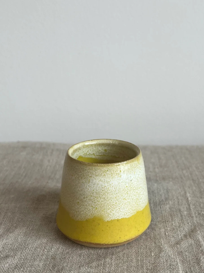 Egg Cup. A simple, yellow egg cup. The bottom ring of the egg cup is a more vibrant yellow.