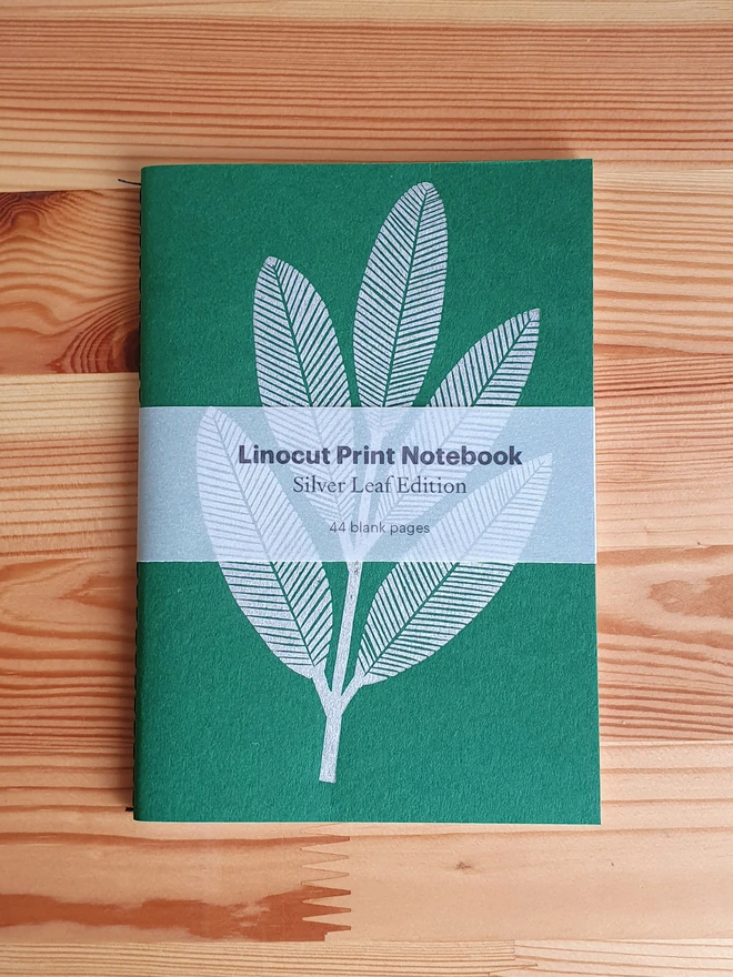 Green notebook with linocut sliver leaf on the cover