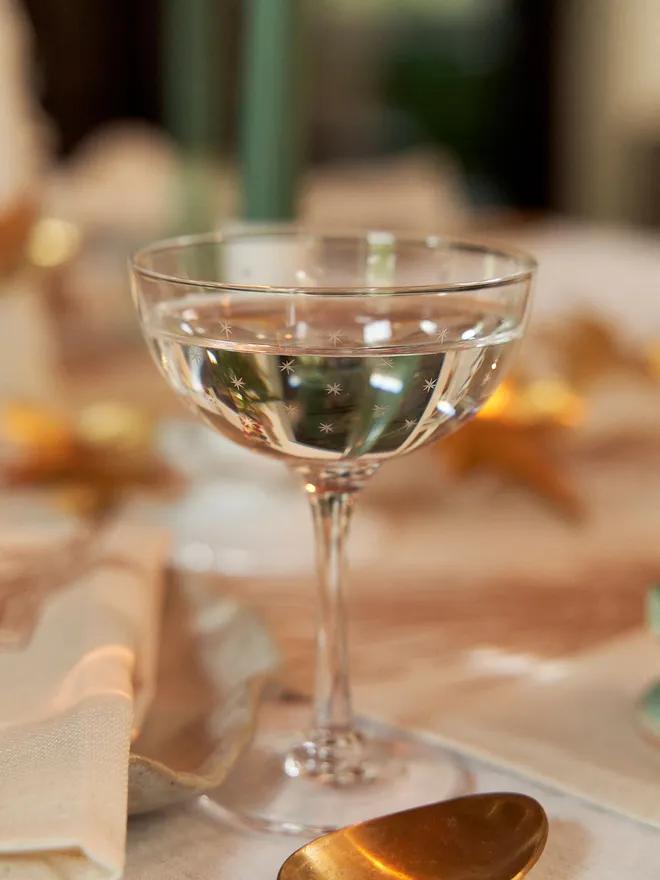 engraved stars crystal champagne saucers. a coupe champagne glass patterned with small stars.