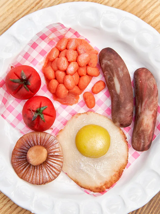 Brekkielicious Marzipan Box, sweet marzipan box displayed on a table surface. In the image are marzipan eggs, beans, mushrooms, tomatoes and sausages along with traditional red and white patterned cloth. 