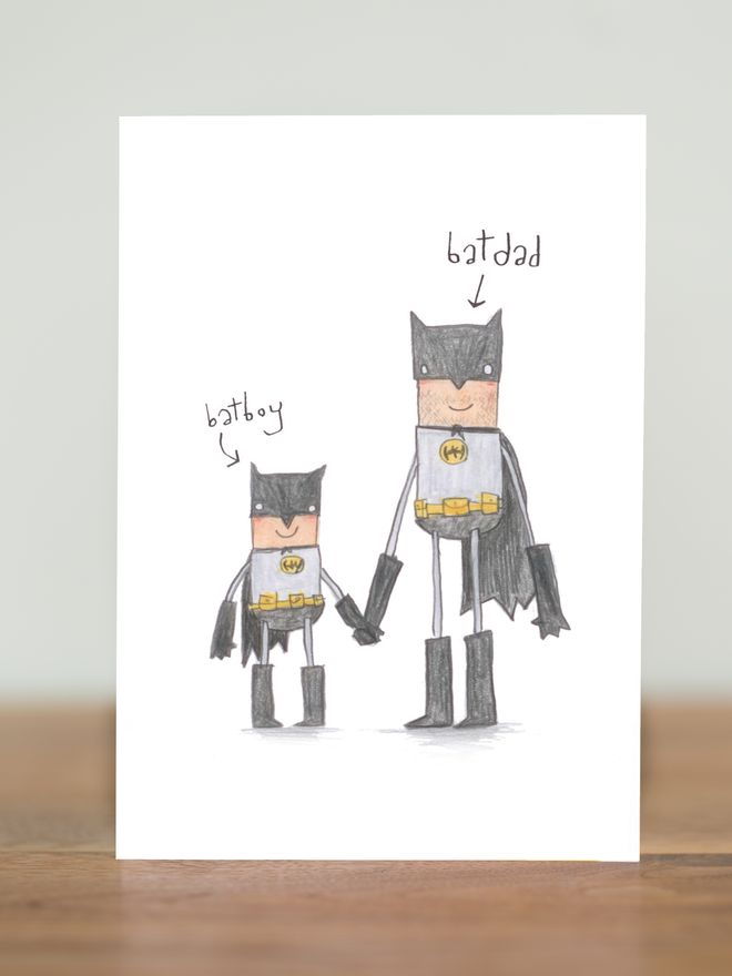 batman superhero fathers day or birthday card. Featuring a father and son superhero team. Funny cards for men with a cute and fun hand drawn illustrated style