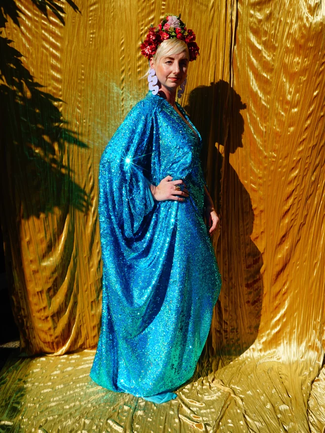 Turquoise Holographic Sequin V-neck Kaftan Gown seen from the side.