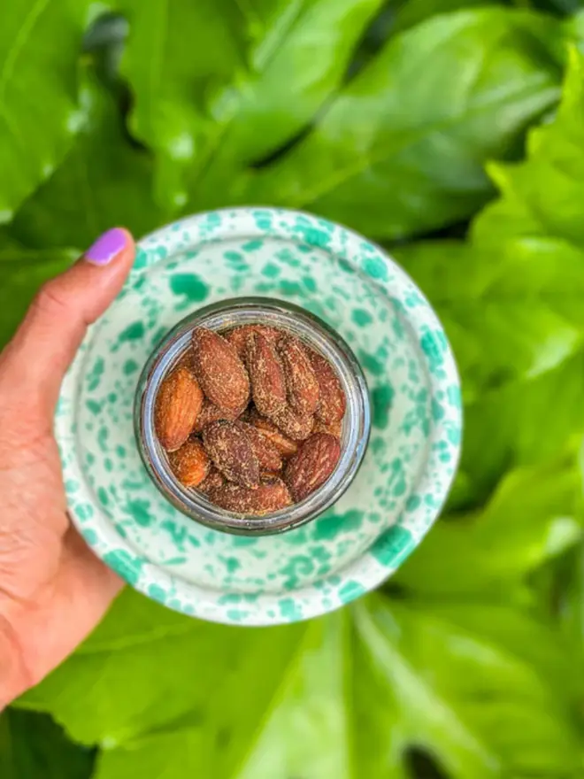 Smoked Rosemary Almonds, on green against a green background. 