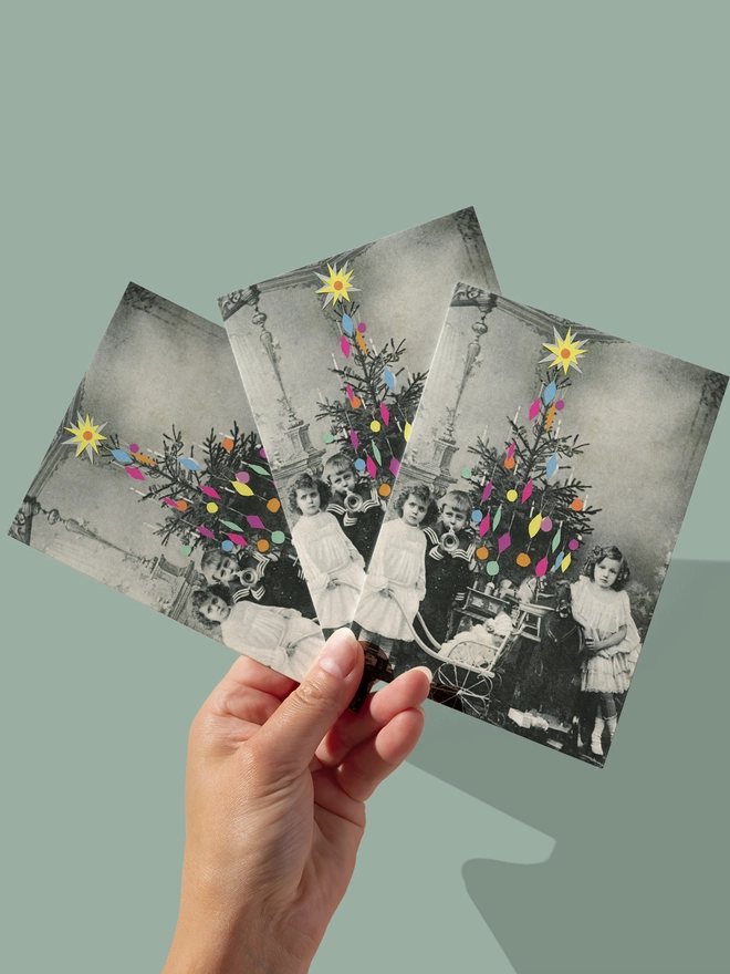 Victorian children stand next to a colourful decorated Christmas tree with their newly opened presents.