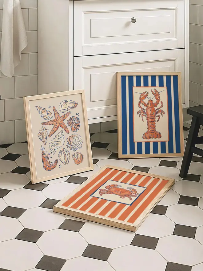 Under the sea art prints on checkered black and white bathroom floor. 